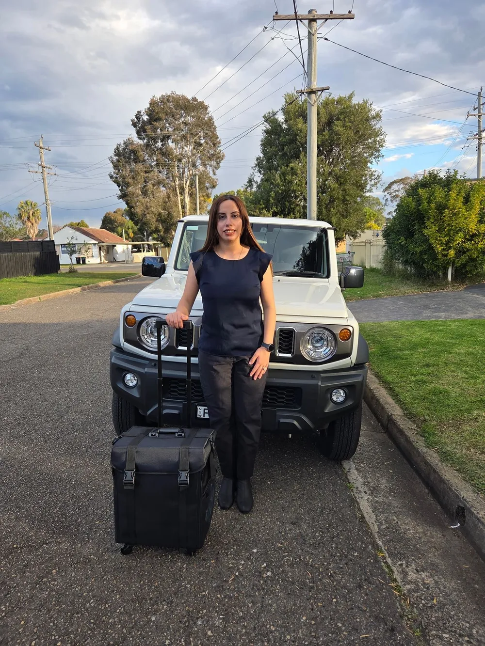 Madleen with her mobile podiatry case beside her car, ready to travel to patients across Sydney