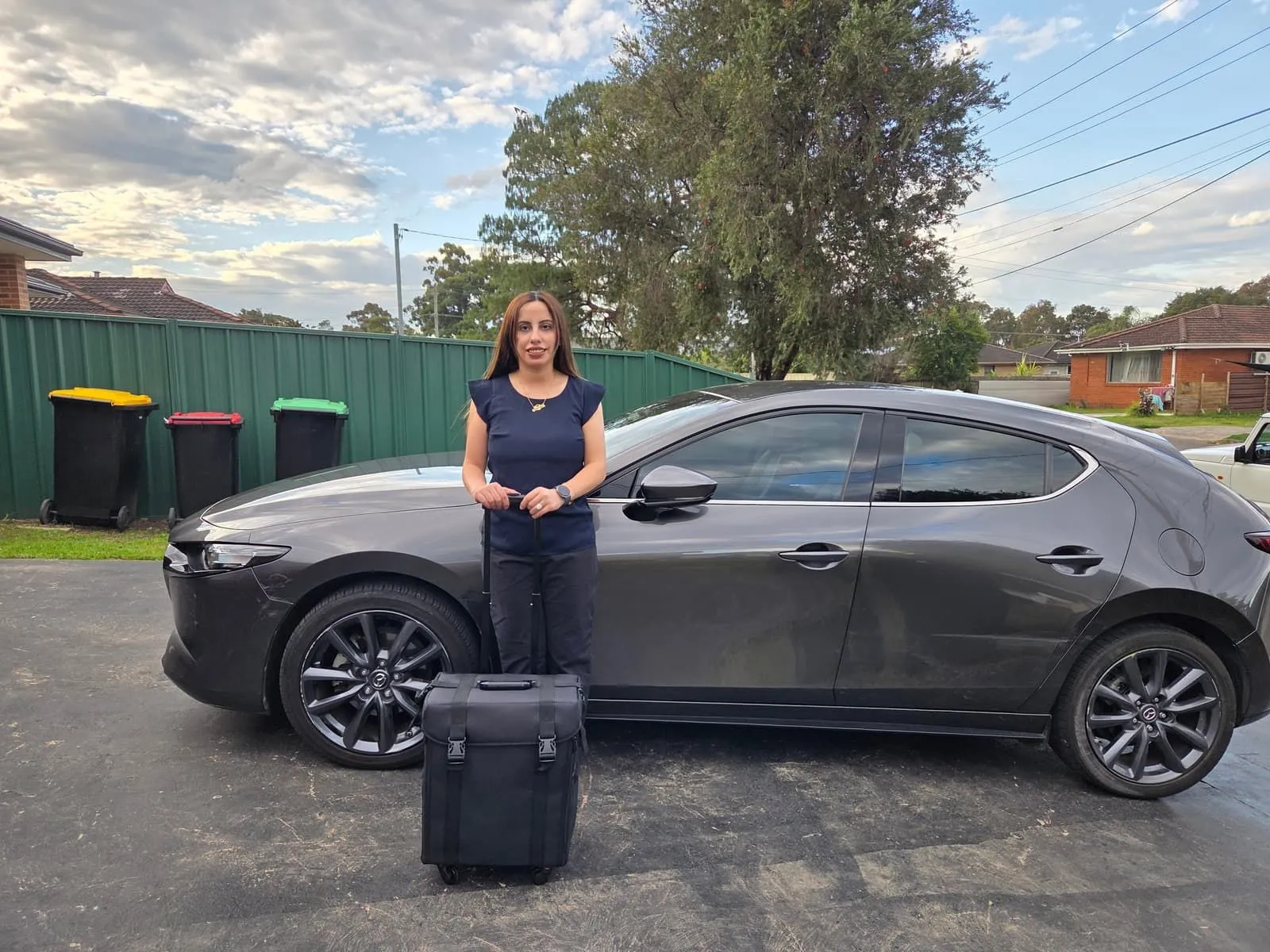 Madleen Farhan, podiatrist at High Steps Podiatry, with her mobile podiatry case beside her car