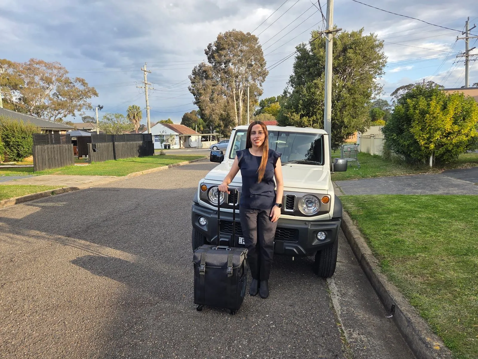 Podiatrist Madleen Farhan with her mobile podiatry case beside her car, ready to travel to a home visit across Sydney