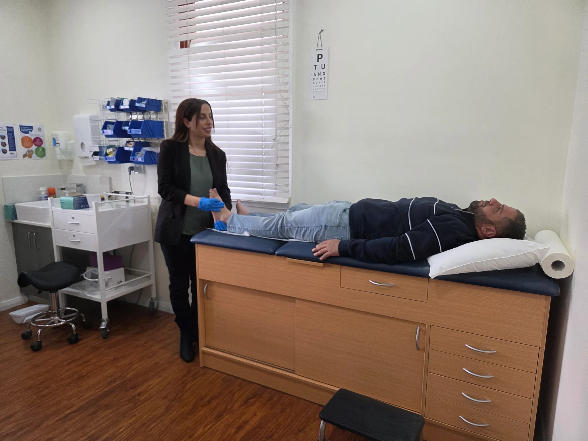 Madleen treating a patient's foot in the High Steps clinic room at Harrington Park