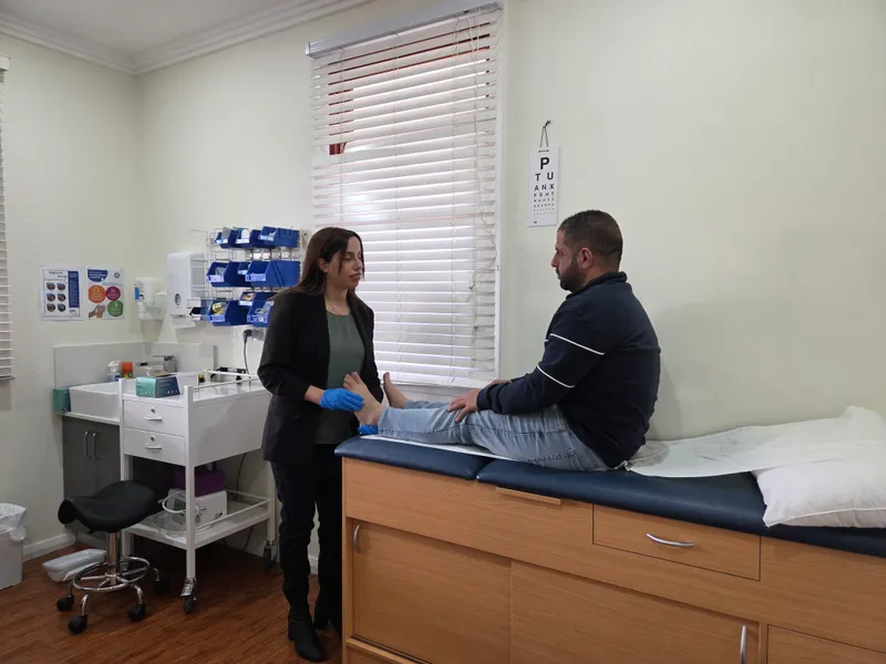 Madleen treating an adult patient's foot in the Harrington Park clinic