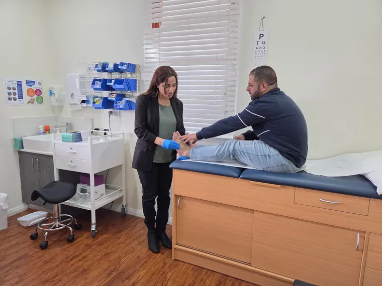 Madleen checking a patient's foot during an appointment
