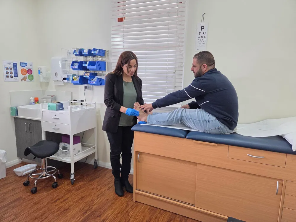 Madleen examining a patient's foot during a clinic appointment