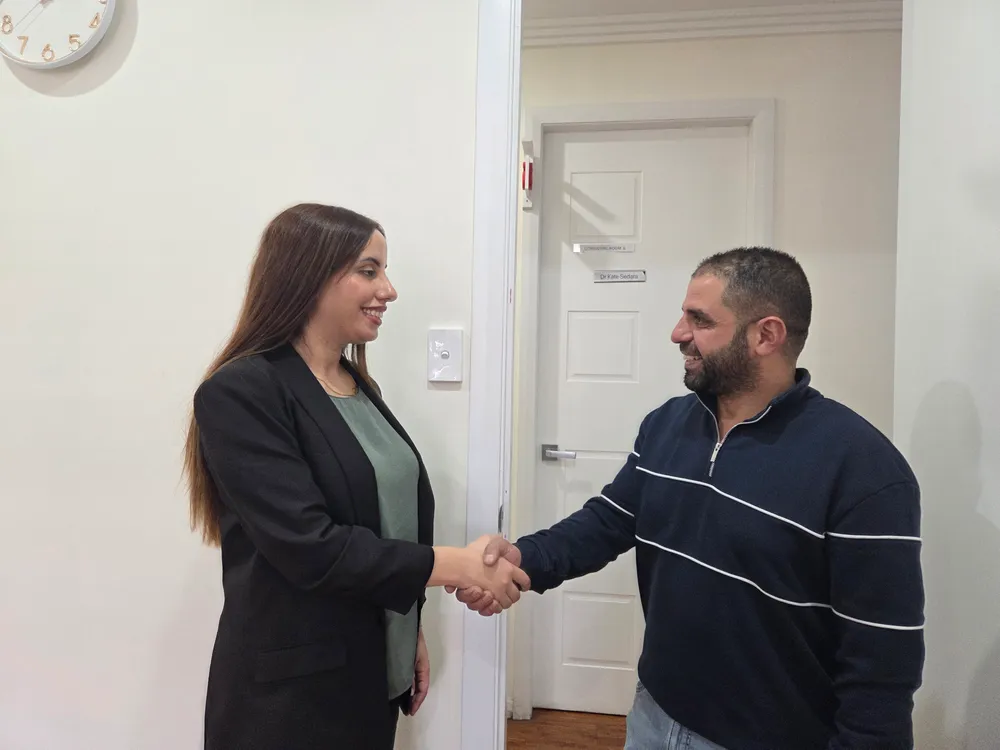 Madleen greeting a patient with a handshake at the Harrington Park clinic